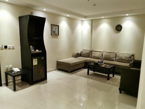 a living room with a couch and a table at لؤلؤة الشرق للشقق المخدومة Luluat Al sharq For Serviced Apartment in Hafr Al Baten