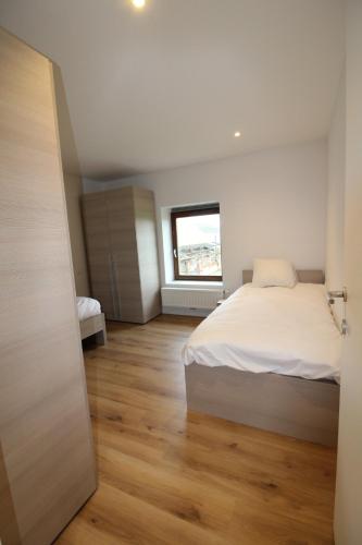a bedroom with a white bed and a window at De Ast by De Oude Kaasmakerij in Passendale
