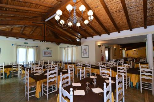 a dining room filled with tables and chairs at Li Suari Club Village in San Teodoro