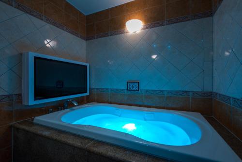 a bathroom with a tub with a flat screen tv at HOTEL Dior7 in Hamamatsu