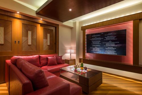 a living room with a red couch and a table at HOTEL Dior7 in Hamamatsu