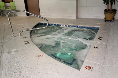 a bath tub with a pool of water on the floor at Holiday Inn Express Hotel & Suites Ashland by IHG in Ashland