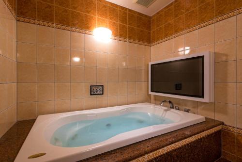 a bath tub with a tv in a bathroom at HOTEL Dior7 in Hamamatsu