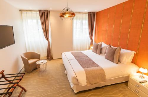 a hotel room with a large bed and a tv at Hotel des Quinconces Bordeaux Centre in Bordeaux
