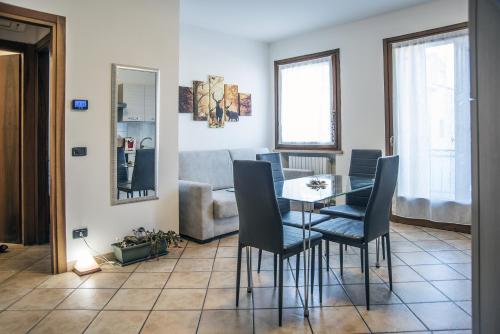 a dining room with a table and chairs and a couch at Residenza Meeting in Verona