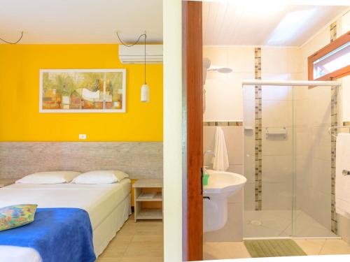 a bedroom with a bed and a bathroom with a shower at Pousada Ecoilha in Ilhabela