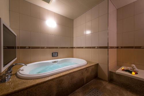 a bath tub in a bathroom with a sink at HOTEL Dior7 in Hamamatsu