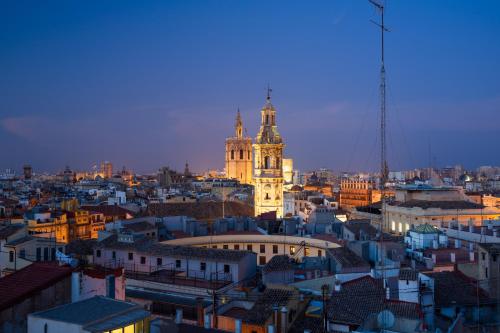 een uitzicht op een stad in de nacht met een klokkentoren bij Valencia Luxury - Boutique Market in Valencia