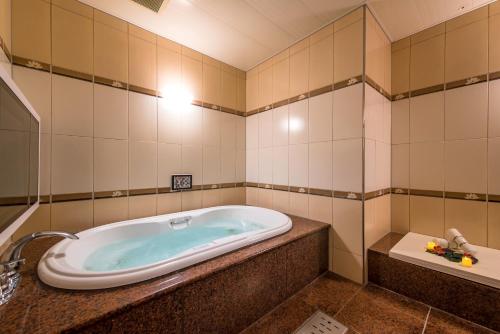 a bath tub in a bathroom with a sink at HOTEL Dior7 in Hamamatsu