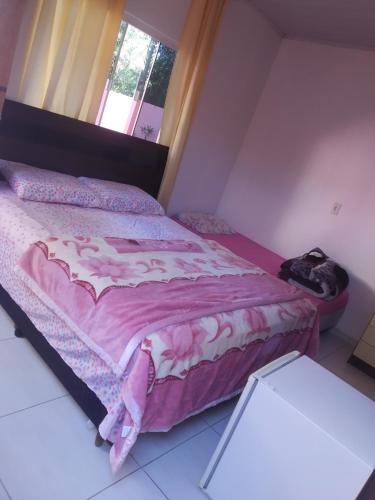 1 dormitorio con 1 cama con manta rosa en pousadavaledasaguas, en Foz do Iguaçu