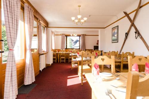 une salle à manger avec des tables et des chaises en bois dans l'établissement Hotel Sylvana, à Megève