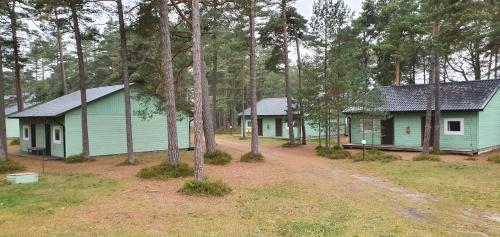 Tuksi Health and Sports Centre في Tuksi: مبنيان أخضر في غابة بها أشجار