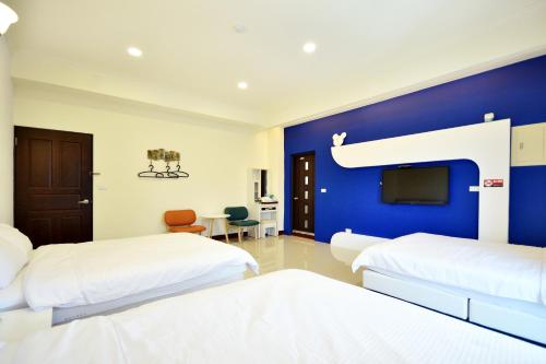 ein Schlafzimmer mit zwei Betten und einer blauen Wand in der Unterkunft Kai Feng B&B in Taitung