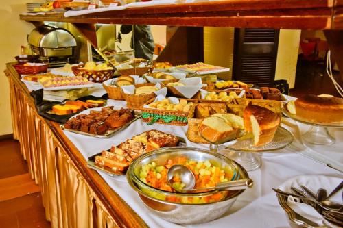 bufet z wieloma różnymi rodzajami żywności na stole w obiekcie Hotel Estoril w mieście Pelotas
