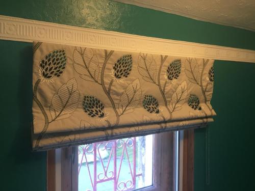 a window with a curtain with a tree pattern at Moorlands in Helensburgh