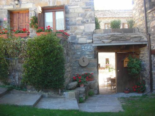 a stone building with a door and a patio at Casa Gallán in Sarvisé