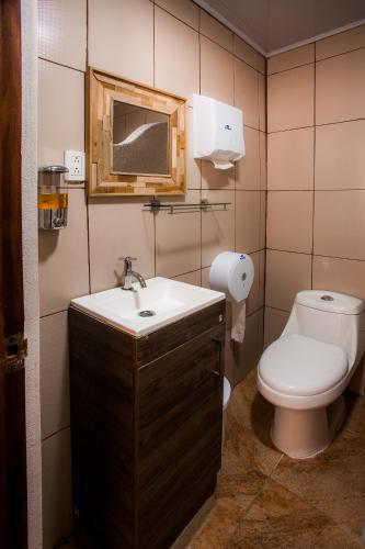 a bathroom with a toilet and a sink and a mirror at Boutique Hotel Casa Orquídeas in San José