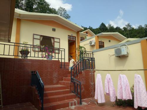 a man standing on the stairs of a house at Hoa Lan Hotel in Bak Kan