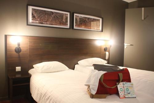 a hotel room with two beds with a backpack on them at Orly Superior Hotel in Athis-Mons