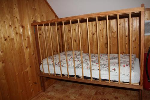 a wooden crib in a room with wooden walls at Chalupa u rybníka Čistá u Horek in Čistá u Horek
