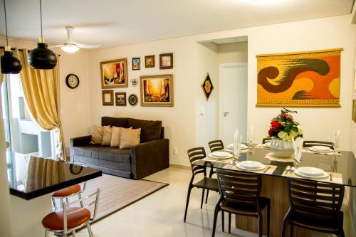 a dining room and living room with a table and chairs at APTO ACONCHEGANTE proximo ao centro in Foz do Iguaçu