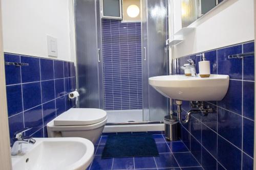 a blue tiled bathroom with a toilet and a sink at Casa Galano in Cetara