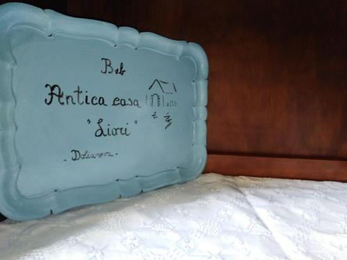 un pastel azul con escritura encima de una cama en Anticacasaliori en Dolianova
