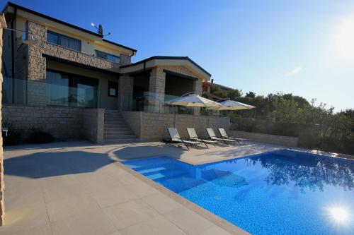 a house with a swimming pool in front of a house at Villa Infinity in Šmrika