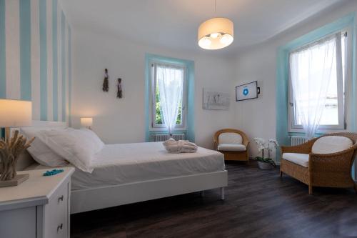 a bedroom with a bed and a chair and windows at Maji Como Lake in Mandello del Lario