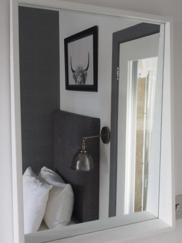 a mirror next to a bed with a bull skull on the wall at Ravenscraig Guest House in Aviemore