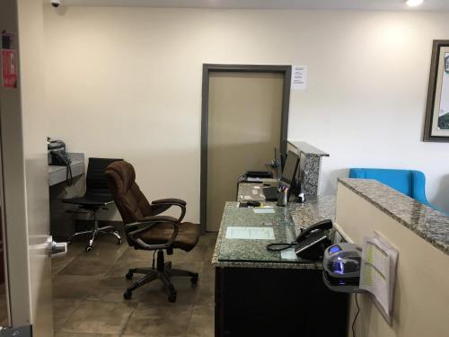 an office with a desk with a computer and a chair at Americas Best Value lnn- Plaquemine in Plaquemine