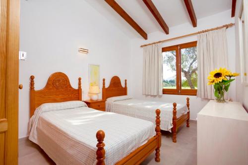 1 dormitorio con 2 camas y ventana en Villa Molinas, en Pollensa