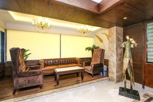 a living room with a couch and two chairs at Hotel Stella Continental in Phagwāra