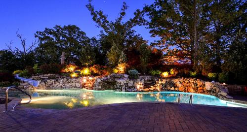 a swimming pool with lights in a yard at night at Chalets Resort Luxury Lakefront Villa Amazing View 2 Pools Free Amenities Dock in Lampe