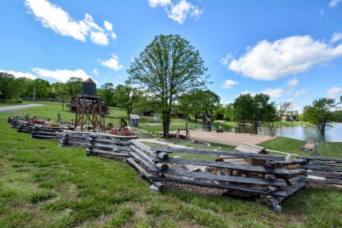 a group of wooden benches in a park with a playground at Chalets Resort Luxury Lakefront Villa Amazing View 2 Pools Free Amenities Dock in Lampe
