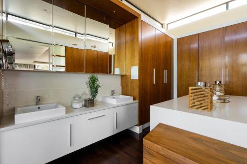 a bathroom with two sinks and wooden cabinets at Umhlanga Beach Villa in Durban