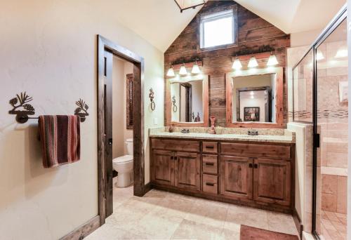 Un baño con lavabo, ducha y espejo. en Luxury Lakefront Villa MiniGolf HUGE POOL Kayaks 2Mi to SDC Dock, en Branson