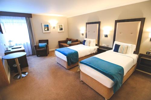 a hotel room with two beds and a couch at Westlodge Hotel & Leisure Centre in Bantry