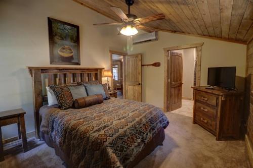 - une chambre avec un lit et une télévision à écran plat dans l'établissement WaterMill Cove Resort LAKEFRONT Cabin 2 mi to Silver Dollar City Pools Mini Golf, à Branson