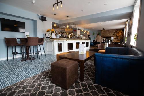 a bar with couches and a table and chairs at Hardwick Arms Hotel in Sedgefield