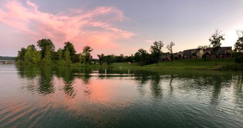 a large body of water with a sunset in the background at 8 Bed Luxury Lakefront Villa Amazing View 2 Pools Free Resort Amenities Dock in Lampe