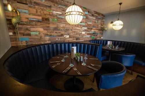 a dining room with a wooden table and blue chairs at Hardwick Arms Hotel in Sedgefield