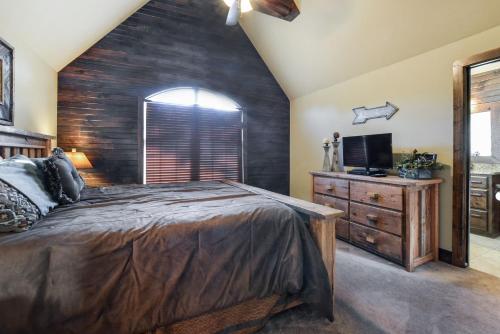 a bedroom with a large bed and a tv at 8 Bed Luxury Lakefront Villa Amazing View 2 Pools Free Resort Amenities Dock in Lampe