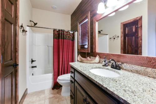 a bathroom with a sink and a toilet and a mirror at 8 Bed Luxury Lakefront Villa Amazing View 2 Pools Free Resort Amenities Dock in Lampe
