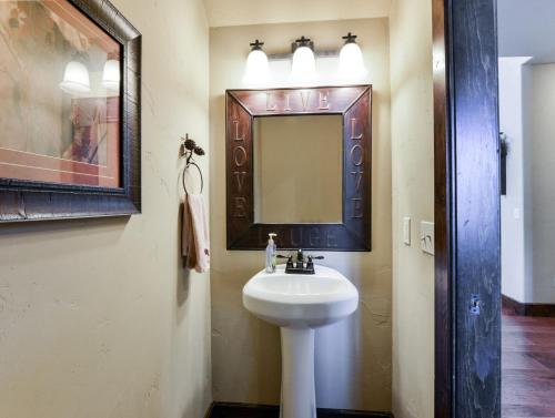 a bathroom with a sink and a mirror at 8 Bed Luxury Lakefront Villa Amazing View 2 Pools Free Resort Amenities Dock in Lampe