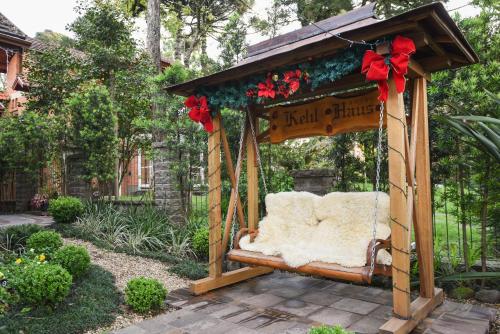 a swing in a garden with red bows at Hotel Kehl Haus in Gramado