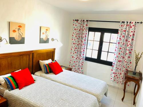 two beds in a room with a window at Tagoror Lanzarote in Puerto del Carmen