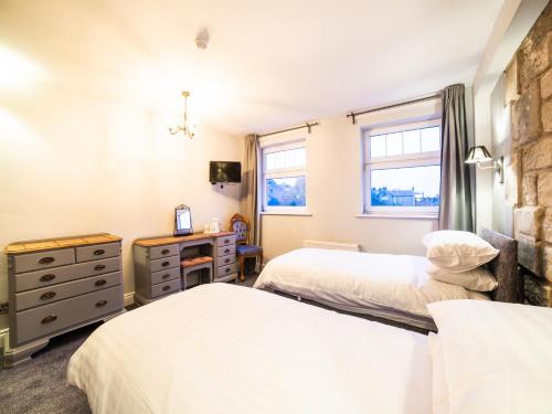 a bedroom with two beds and a window at Churchill's Hotel in Wombwell