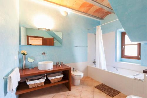 a bathroom with a sink and a toilet and a tub at Villa La Corbaia in Artá