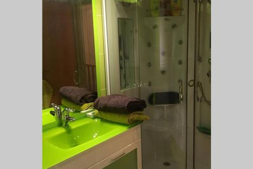 y baño con lavabo verde y ducha. en A Casinha rústica com todo o conforto, en Aldeia da Ponte